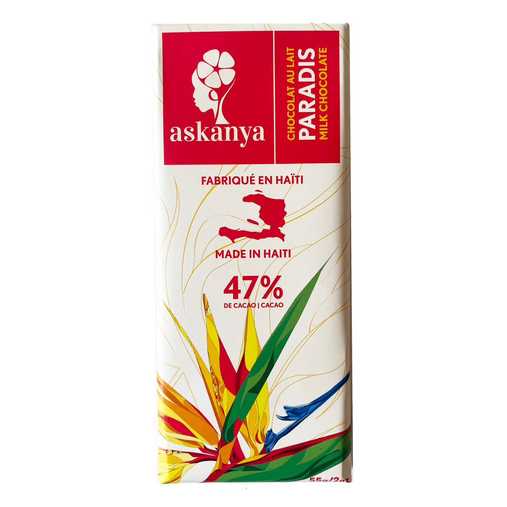 White packaging with Bird of Paradise (Haitian flower). Sticker with company logo (Askanya) and chocolate flavor information - Milk Chocolate  called “Paradis”. Packaging also shows Haiti country map and cacao percentage in chocolate bar: 47%. Chocolate bar is 55g or 2oz.